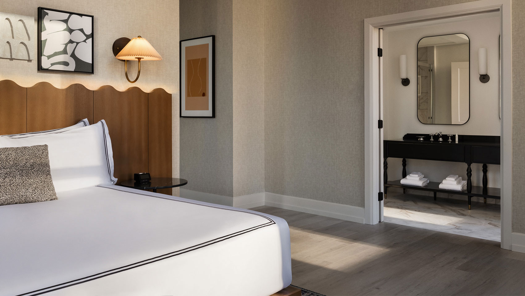 guest room bed with view of bathroom at kimpton hotel monaco baltimore